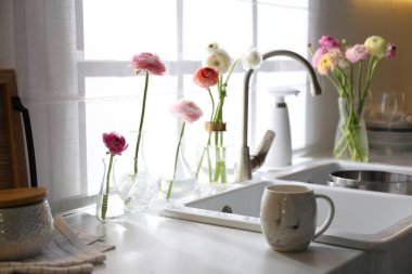 Açık mutfak güzel taze ranunculus çiçekleriyle süslenmiş.