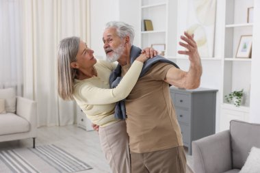 Güzel yaşlı çift evde dans ediyor.