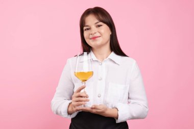 Pembe arka planda beyaz şarap kadehi olan profesyonel şarap garsonu.