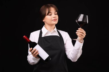 Siyah arka planda kırmızı şarap ve şişe olan profesyonel şarap garsonu.
