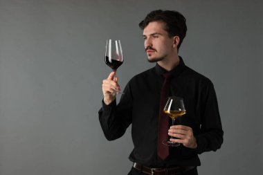 Gri arka planda şarap kadehleri olan profesyonel şarap garsonu.