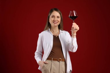 Kırmızı arka planda şarap kadehi olan profesyonel şarap garsonu.