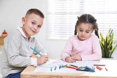 Çocuklar kalemle çizim yapıyorlar.