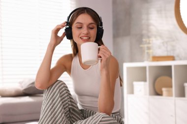 Kahveli güzel bir kadın evde müzik dinliyor.