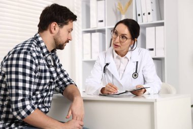 Klinikteki beyaz masada pano danışmanı olan bir doktor.