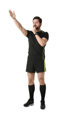 Üniformalı hakem beyaz arka planda düdük çalıyor.