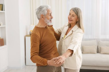 Güzel yaşlı çift evde dans ediyor.