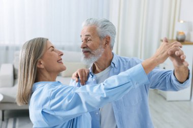 Güzel yaşlı çift evde dans ediyor.