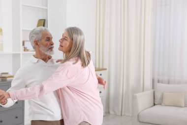 Güzel yaşlı çift evde dans ediyor. Metin için boşluk