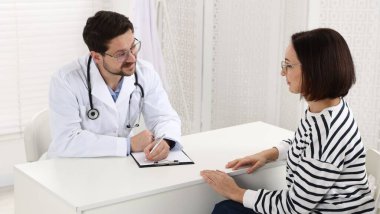 Klinikteki beyaz masada pano danışmanı olan bir doktor.