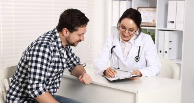 Klinikteki beyaz masada pano danışmanı olan bir doktor.