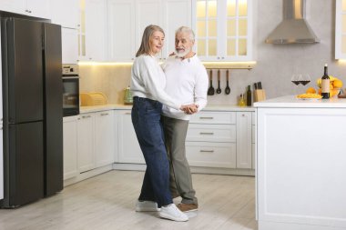 Mutlu son sınıf çifti mutfakta dans ediyor.