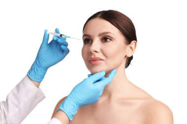 Estetik ameliyat. Doktor beyaz arka plandaki hastaya yüz enjeksiyonu yapıyor.