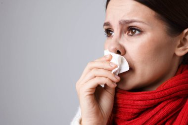 Hafif arka planda burnu akan bir kadın, yakın plan ve mesaj için yeri var. Soğuk Semptom