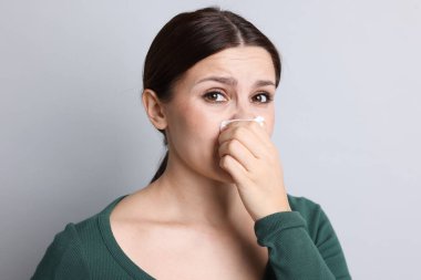 Hafif arka planda burnu akan bir kadın. Soğuk Semptom