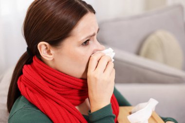 Evde burnu akan bir kadın, yakın plan. Soğuk Semptom