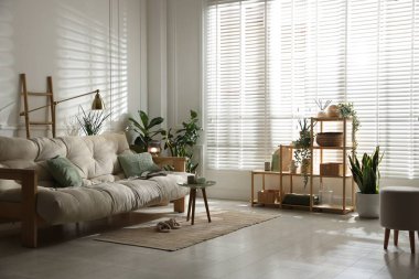 Kanepesi ve çiçekleri olan şık bir oturma odası. İç tasarım