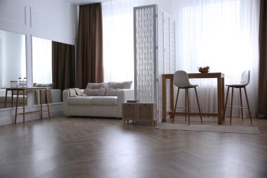 Parke zemin ve şık mobilyaları olan modern oturma odası.