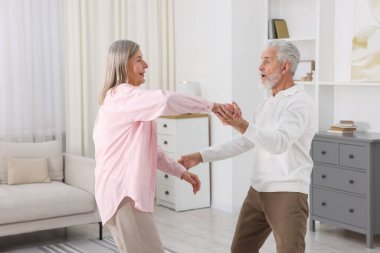 Güzel yaşlı çift evde dans ediyor.