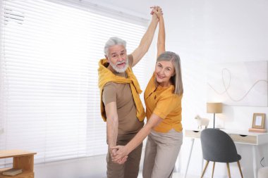 Güzel yaşlı çift evde dans ediyor.