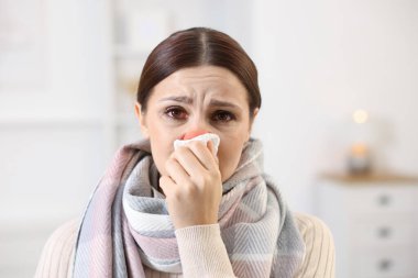 Evde soğuktan acı çeken dokusu olan bir kadın. Kırmızı gözler ve burun.