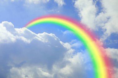 Parlak renkli gökkuşağı ve mavi gökyüzündeki bulutlar
