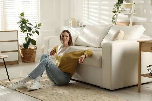 Evdeki koltuğun yanında dinlenen bir kadın.