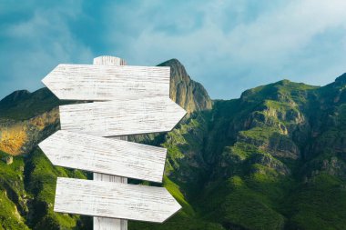 Dağlara karşı farklı yönlere bakan okları olan tahta tabela direği.