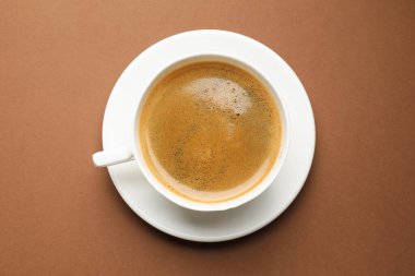 Kahverengi arka planda, fincanda koyu kahve, üst manzara.