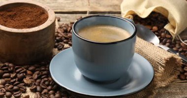 Ahşap masada, fincanda aromatik kahve içen kadın, yakın plan.