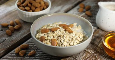 Tahta masada yulaf ezmesi ve fındıklı badem sütü dök, yakın plan.