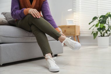 Pouf 'un üzerinde şık ayakkabılar giyen bir kadın, yakın plan. Metin için boşluk