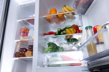 Farklı taze gıda ürünleri ve düşük açılı manzaralı modern buzdolabı.