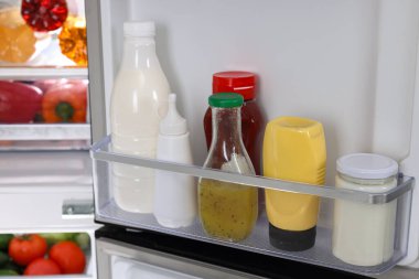 Farklı taze gıda ürünleri olan modern buzdolabı, yakın plan.