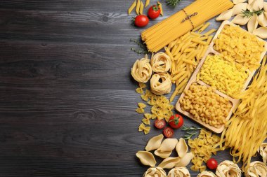 Farklı türde çiğ makarna, domates, biberiye ve kekik. Metin için boşluk