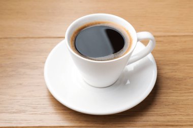 Ahşap masada, fincanda Aromatik kahve, yakın plan.