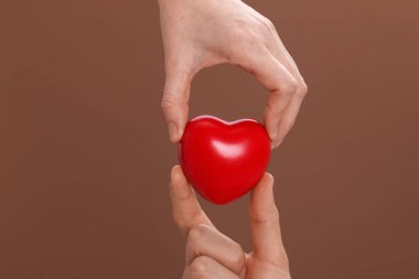 Kahverengi arka planda kırmızı dekoratif kalbi olanlar, yakın plan.