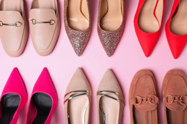 Pembe arka planda farklı güzel ayakkabılar, düz yatış.