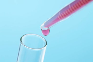 Tüp bebek tedavisinde. Sıvı numuneli boru ve açık mavi arka planda test tüpü, yakın plan