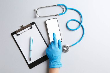 Sağlığınıza. Akıllı telefon, steteskop, pano ve kalemle aydınlık masa, üst görünüm.