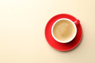 Bej arka plan masasında bir fincan aromatik kahve, üst manzara. Metin için boşluk