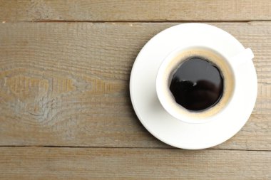 Ahşap masanın üzerinde bir fincan aromatik kahve, üst manzara. Metin için boşluk
