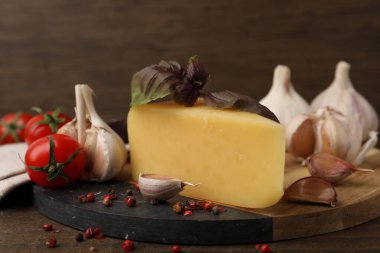 Süt ürünü. Peynir, domates, fesleğen, biber ve sarımsak, ahşap masa, yakın plan.