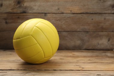 Ahşap masada parlak bir voleybol topu, yazı için boşluk.