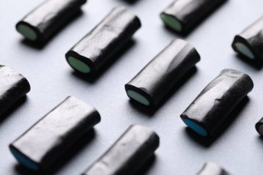 Gri arkaplanda doğal meyan kökü şekeri, yakın plan.