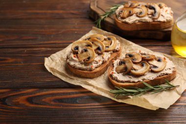 Ahşap masada ezmeli, mantarlı ve baharatlı lezzetli bruschettalar, yakın plan. Metin için boşluk