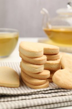 Lezzetli kalp şeklinde kurabiyeler ve çay, yakın plan.