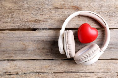 Kulaklıklar ve kalp figürleri ahşap masa, üst manzara. Metin için boşluk