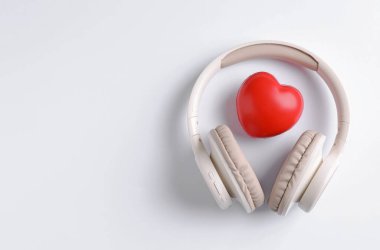 Kulaklıklar ve kalp figürleri beyaz arka planda, üst manzara. Metin için boşluk