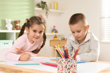 Çocuklar kalemle çizim yapıyorlar.